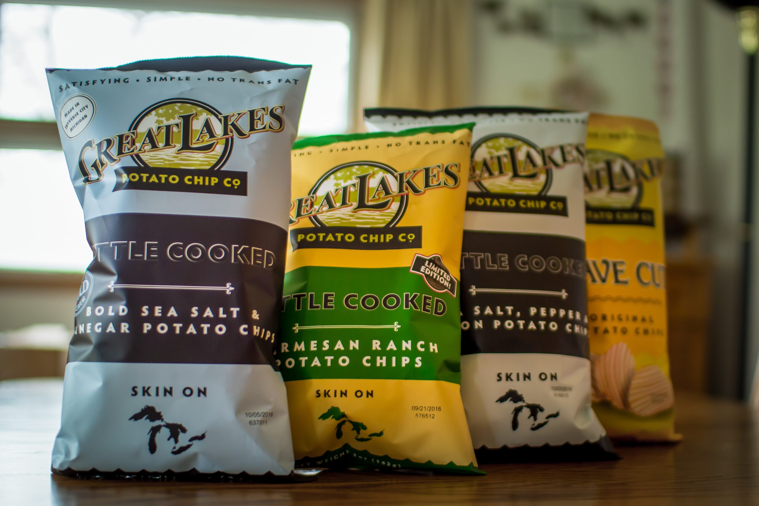 Japanese Omiyage 1 Four bags of potato chips proudly lines up on a table in house, alternating between a blue bag and a yellow bag