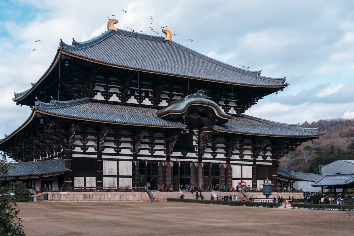Things to do in Nara 2 Two story Japanese temple standing proudly against a cloud filled blue sky as a popular spot for things to do in Nara