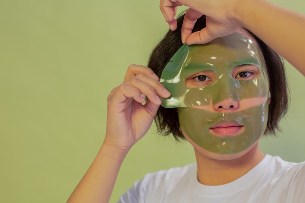 Japanese Skincare 4 An asian man applying the top half of a 2 part face mask as an alternative step in the japanese skincare process