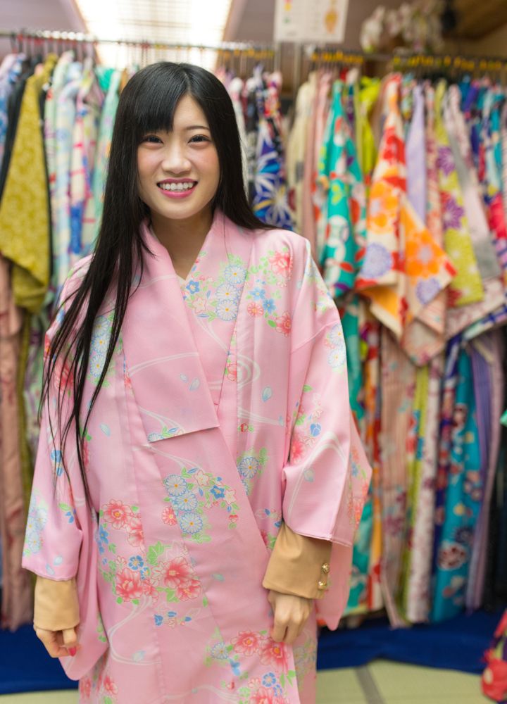Kimono Rental 4 Woman wearing a pink kimono with a weaving floral design in a kimono store