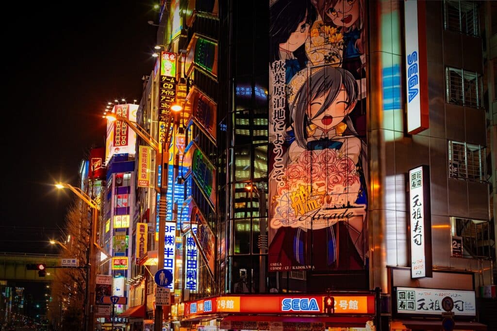 akihabara-pexels (1) scenery of akihabara at night with a billboard of an anime girl holding a bouquet of flowers