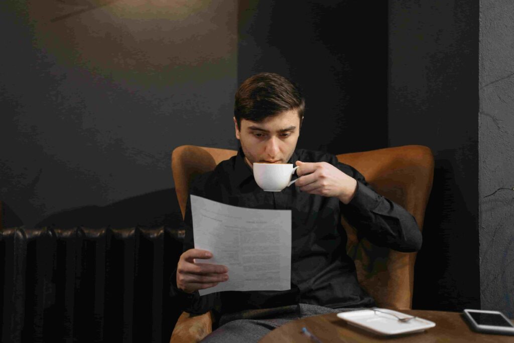 a man studying with cofee in hand